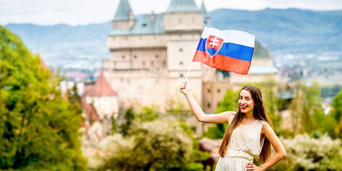 turystka z flagą słowacką na tle zamku Bojnice.